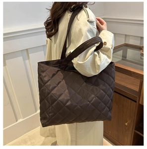 Deep brown quilted tote bag with glossy finish shown on model for commuting style