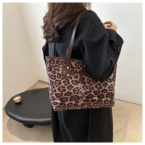 Chic leopard print tote bag with brown straps and gold studs shown on a model