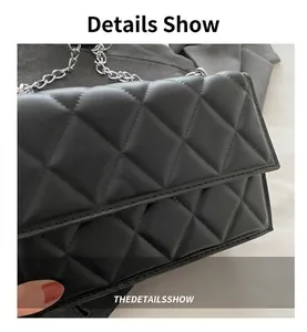 Detailed macro view of black quilted leather texture and silver metal chain strap