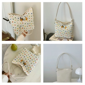 Detailansicht der cremefarbenen Canvas-Tasche mit bunten Punkten und Hundestickerei