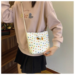 Schultertasche aus Canvas mit bunten Punkten und Hundestickerei am Modell