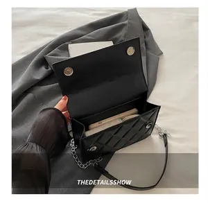 Interior view showing capacity for wallet and phone in black quilted crossbody chain bag