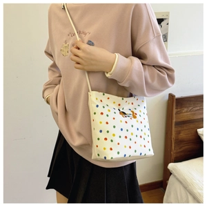 Mädchen mit Polka-Dot Segeltuchtasche kombiniert mit Sweatshirt und Faltenrock Outfit