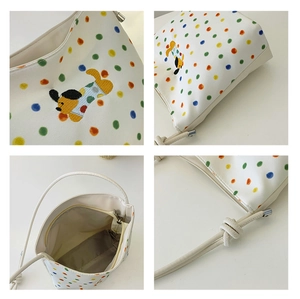 Detailansicht der bunten Polka-Dots und Cartoon-Hundestickerei auf der Segeltuchtasche