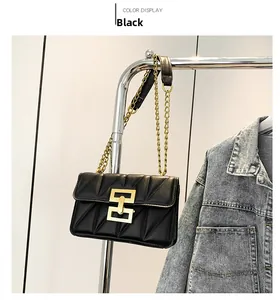 Détail du sac bandoulière matelassé noir avec fermoir géométrique doré et chaîne