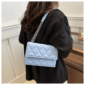 Macro shot of light blue quilted crossbody bag with silver chain strap and PU leather detail