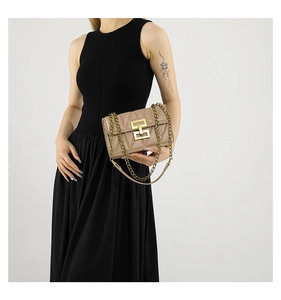 Détail d'un sac bandoulière beige matelassé avec fermoir H doré et chaîne métal