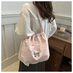 Detailed view of light pink bucket bag with silver bow and cloud pleated texture