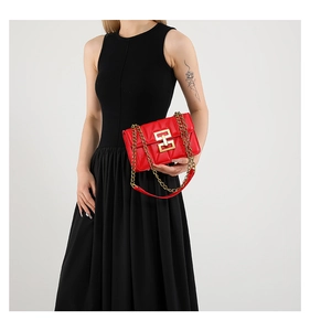 Détail du sac matelassé rouge avec fermoir doré et bandoulière en chaîne dorée