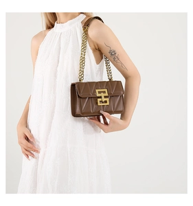 Détail d'un sac à bandoulière en cuir marron matelassé avec chaîne dorée et boucle chic