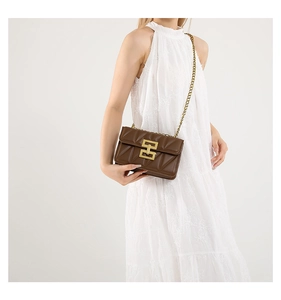Détail d'un sac à bandoulière en cuir matelassé marron avec fermoir doré et chaîne