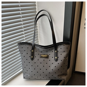 Detailed view of the gray polka dot tote bag with leather strap and fashion gold logo