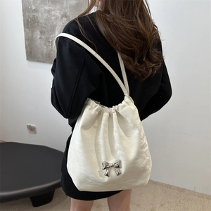 Chic white pleated shoulder bag with silver bow accent and adjustable drawstring