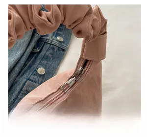 Gros plan sur la fermeture éclair lisse en métal d'un sac à main rose plissé