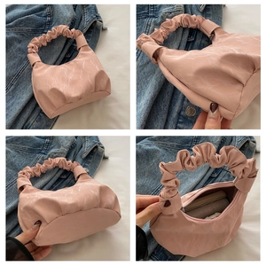 Détail du sac à main rose avec poignée froncée, texture marbrée et vue intérieure