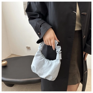 Détail du sac croissant bleu clair avec anse froncée et tissu au fini satiné