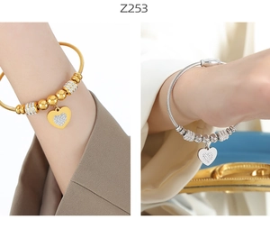 Detail of titanium steel wire bracelets with zircon heart charms in gold and silver finish