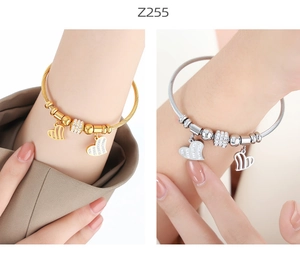 Detail of twisted cable bracelet featuring pavé heart charms in gold and silver finish