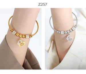 Close-up of gold and silver steel wire bangles with hollow heart Love charms and zircons