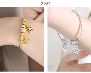Detailed shot of cable wire bracelets with star charms in gold and silver finish