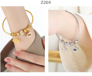Detail of cable wire bracelets with evil eye charms and rhinestones in gold and silver