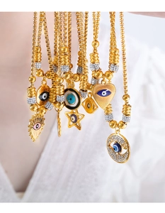 Detail of gold evil eye heart and star necklaces with crystals on box chains