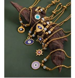 Close-up of golden evil eye charm bracelets with colorful enamel on natural wood