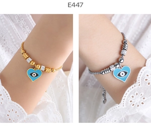 Close-up of gold and silver heart-shaped evil eye bracelets with blue enamel finish