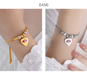 Detail of gold and silver heart bracelets with evil eye charm and zircon stones