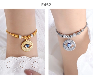 Close-up of evil eye charm bracelets in gold and silver finish with crystal details
