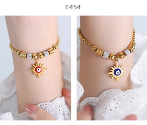 Detailed shot of gold sun evil eye bracelets with red and blue enamel and crystal beads