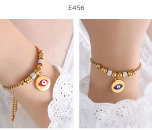 Detail of evil eye charm bracelets in red and blue enamel with 18k gold plated beads