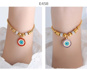 Close-up of golden beaded Evil Eye charm bracelets with zircon accents on a white background