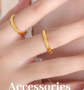 Detailed view of gold bamboo joint rings with textured metal finish on finger