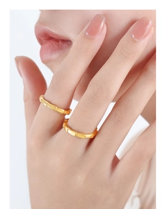 Detail of two golden bamboo style rings featuring metallic texture and stackable design