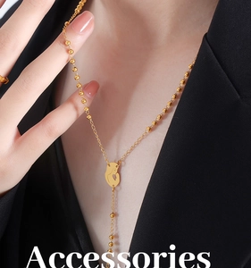 Detail of gold Y-shaped necklace featuring a mother-child silhouette pendant on beads chain