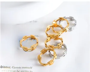 Macro di anelli a spina d'oro e d'argento impilati su carta di un libro vintage