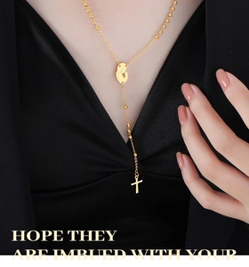 Detail of gold rosary necklace with virgin mary medallion and long cross pendant on model