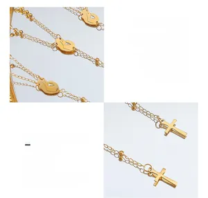 Detail of 18K gold plated titanium long necklace with cross and human figure pendants