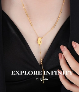 Close-up of gold Y-shaped necklace with cross and portrait pendants on model
