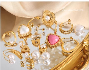 Ensemble de boucles d'oreilles vintage dorées avec perles et pendentifs sur miroir