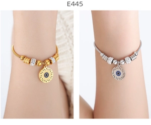 Detalle de pulseras de ojo turco en oro y plata con cuentas de cristal en la muñeca