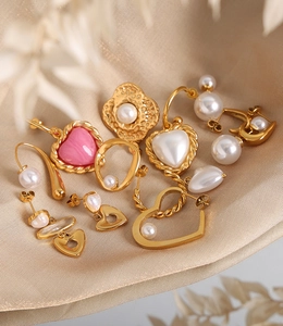 Détails de breloques cœur dorées et perles sur un tissu en satin champagne