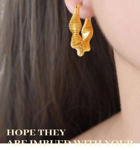 Detail of twisted spiral texture and gold-plated craftsmanship on large hoop earrings