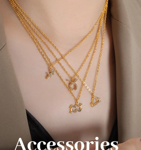 Detailed view of layered gold-plated zodiac pendants with sparkling crystals on chains