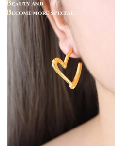Detailed view of heart-shaped gold titanium earrings with elegant twisted texture
