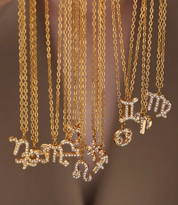 Macro shot of gold-plated zodiac pendants with sparkling crystals and fine metalwork