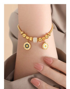 Detailed shot of golden beaded bracelet with Roman numerals and rhinestone barrel charms