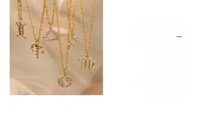 Macro detail of 18K gold plated zodiac pendants with crystals on champagne silk background