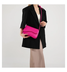 Détail du sac bandoulière fuchsia tendance avec rabat ondulé et texture cuir lisse